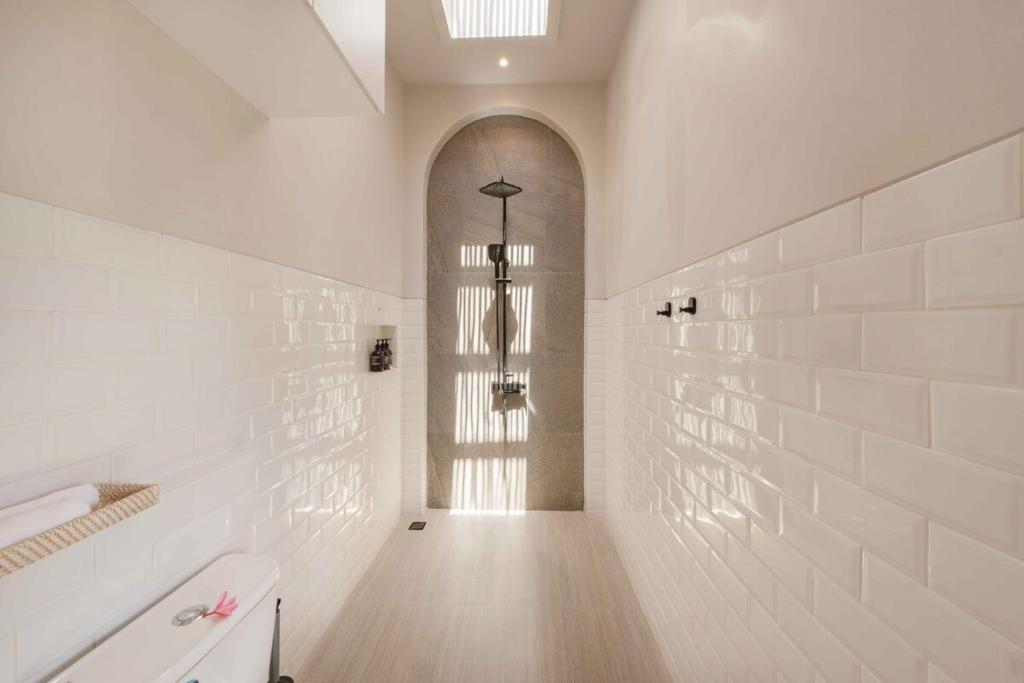 Helles Badezimmer mit Regendusche und Metro-Fliesen in der Amartya Villa 7