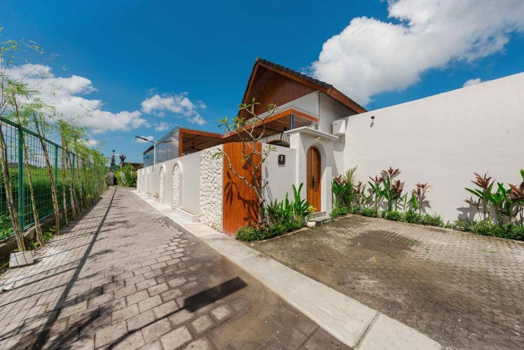 Außenansicht der Amartya Villa 7 in Ubud-Singakerta mit Holz-Eingangstor und Bambushain