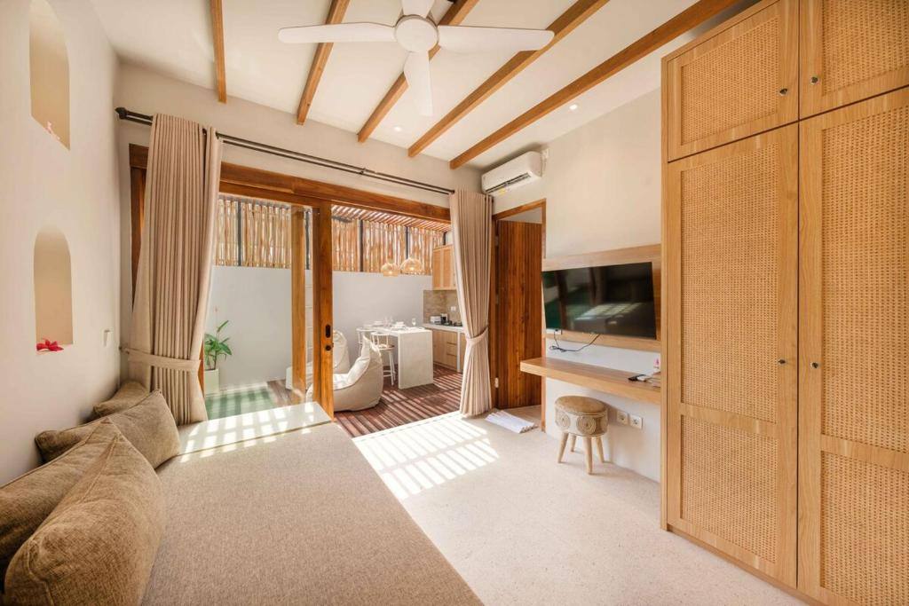 Wohnbereich mit Deckenventilator, Rattan-Schrank und Blick zur Küche