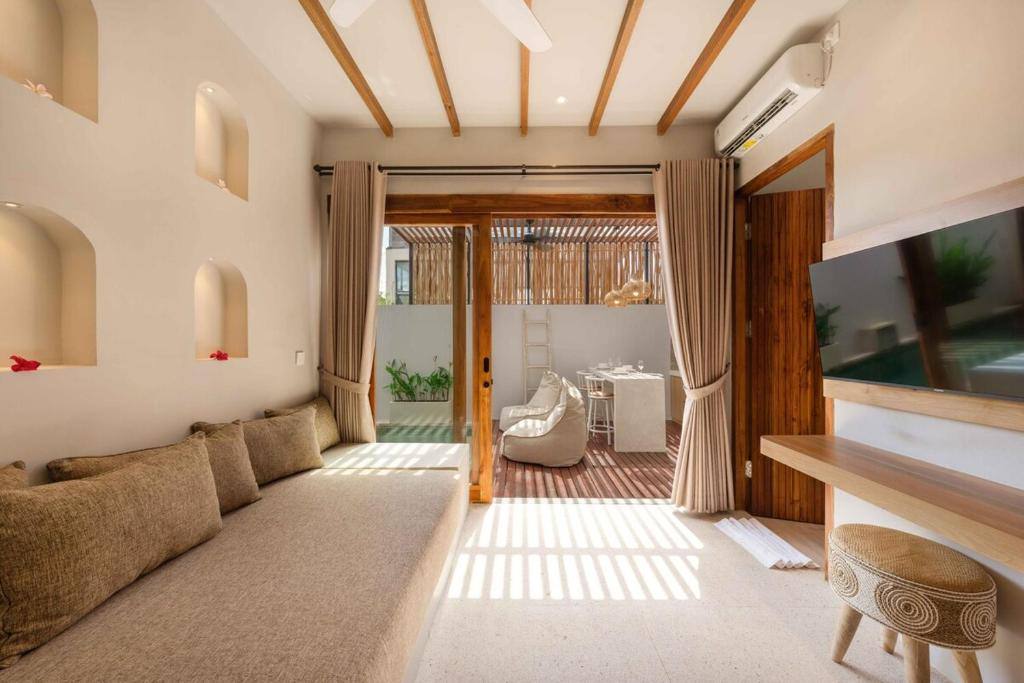 Heller Wohnbereich der Amartya Villa 7 mit Teakholz, Rattan und natürlichem Tageslicht