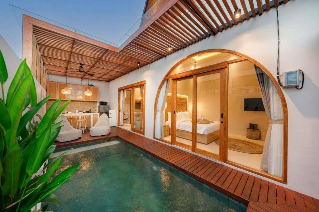 Privater Pool mit Bogentür zum Schlafzimmer und offener Küche